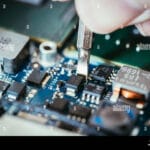 computer-circuit-board-hand-and-screwdriver-technician-is-fixing-a-motherboard-RRNNAR-3055841355